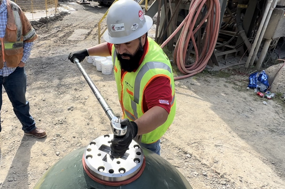 A man tightening the Excel Foundry UltraBolt on a crusher.